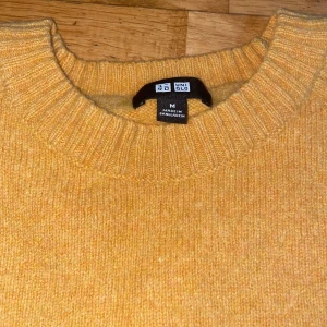 Gul stickad tröja från Uniqlo - Säljer en jätteskön gul stickad tröja från Uniqlo. Tröjan är i nytt skick använt 1 gång. Perfekt för höst och vinter med sin varma och sköna känsla. Tröjan har långa ärmar och ribbade muddar vid ärmslut och nederkant. Passar perfekt för en avslappnad stil. 🧡