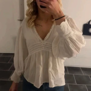 Vit blus med spetsdetaljer - Säljer en superfin vit blus med v-ringning och söta detaljer. Köpt här på plick men aldrig använd, lånad bild 🥰