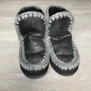 Mörka Mou skor - Säljer ett par mörka Mou skor i mycket bra skick. De är gjorda i skinn med snygga grå stickade detaljer runt kanterna. Bara använda ett fåtal gånger💝