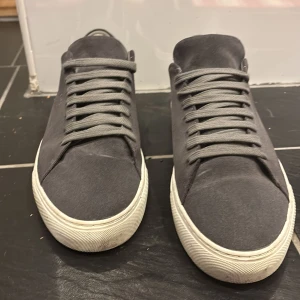 Grå sneakers från Axel Arigato - Säljer ett par stilrena grå sneakers från Axel Arigato i mycket bra skick. Skorna är gjorda i mocka med en vit sula och har klassisk snörning. Perfekta för både vardag och fest! Kommer med originalpåse. Pris går o diskutera 
