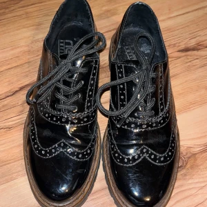 Svarta lackskor  - Super söta lack skor med mönster runt om på skorna, fina kostym skor. Några revor på sidan av skorna, men det är inget som syns, annars väldigt bra skick. Storlek 38, nästan inte använda. Nypris runt 600 kr.  Skriv för mer info eller bilder! 💕