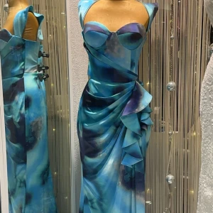 Blå långklänning med drapering - Säljer en fantastisk blå långklänning med vackra draperingar och breda axelband. Klänningen har en elegant omlott-design och är perfekt för festliga tillfällen. Materialet är mjukt och glänsande, vilket ger en lyxig känsla. Perfekt för att sticka ut på festen! 💙