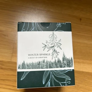 Doftljus Winter Sparkle - Säljer ett mysigt doftljus som heter Winter Sparkle från A Scent of Christmas. Ljuset kommer i en snygg förpackning med vintertema och har en fräsch doft som påminner om jul. Perfekt för att skapa stämning under kalla vinterkvällar. 🕯️✨
