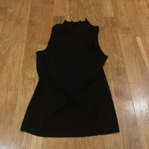 Svart ärmlös topp från H&M - Snygg svart ärmlös topp från H&M i storlek S. Är även en högre krage Perfekt för både vardag och festliga tillfällen. 