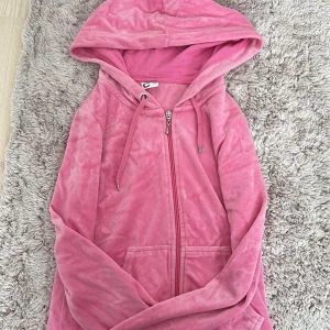 Rosa hoodie med dragkedja - Mysig rosa hoodie i storlek XS från märket C. Den har en dragkedja framtill och en praktisk huva med snörning. Perfekt för en avslappnad stil och passar bra till både vår och höst. Materialet känns mjukt och bekvämt mot huden.💖