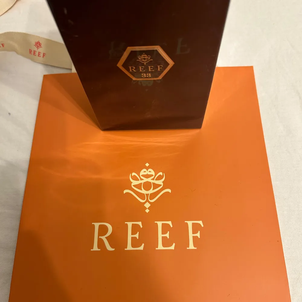 Reef 33 Eau de Parfum (100 ml) Upptäck en doft som kombinerar fräschör och styrka för att skapa en perfekt balans av elegans och kraft. Reef 33 öppnar med livliga toppnoter av bergamott och grapefrukt, ett sofistikerat hjärta av lavendel och kardemumma, och avslutas med en varm bas av cederträ och amber. Perfekt för varje tillfälle. Till kommer en orange påse.. Perfume.
