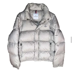 Beige pufferjacka från Moncler - Säljer en snygg beige pufferjacka från Moncler. En schysst moncler jacka som man även kan smidigt bygga om till en väst. En flaw som man ser på sista bilden men väldigt svår att se i verkligheten. Äktighetsbevis finns. Pris kan diskuteras!