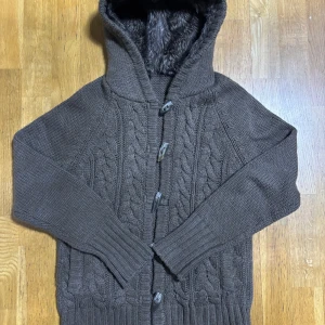 Fodrad Cardigan med Päls- Cardigan Med Päls - Färgen kan se grå ut men den är Brun!! Säljer nu en as fet och extremt eftertraktad päls cardigan som blivit mycket populär nu, extremt svåra att hitta överhuvudtaget men denna är i nyskick! Storlek M-L. Märken som Loro Piana och Rose & Born har liknade varianter men för 10 gånger så mer! PRIS KAN DISKUTERAS!!! Skriv gärna vid frågor🤝