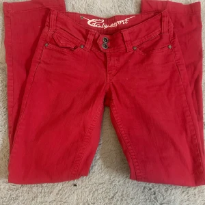 Röda byxor från Esprit - Snygga lågmidjade utsvängda röda byxor från Esprit med knappar och dragkedja framtill. Säljer då de är för stora