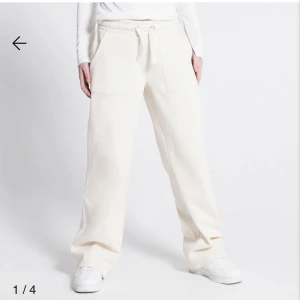 Vita mjukisbyxor  - Snygga och bekväma vita mjukisbyxor med dragsko i midjan. Byxorna har en loose passform och raka ben, vilket ger en avslappnad stil. Perfekta för en chill dag hemma eller en avslappnad promenad.