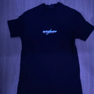 Svart t-shirt med tryck från FSBN - Snygg svart t-shirt från FSBN med ett coolt tryck på både fram- och baksidan. Framsidan har en liten text medan baksidan visar en jordglob med texten 'WRLD WIDE'. Perfekt för en avslappnad stil.