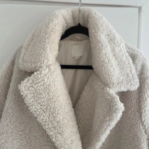 Vit beige teddyjacka - Snygg vit/beige teddy kappa som både värmer och klär upp dig, som tyvärr inte längre kommer till användning. 