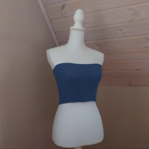 Blå virkad tubtopp - Snygg blå virkad tubtopp perfekt för sommardagar. Den har en tight passform som framhäver figuren. En stilren topp som enkelt kan matchas med olika outfits.