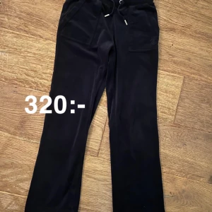 Juicy Couture mörkblå mjukisbyxor - Snygga mörkblå mjukisbyxor från Juicy Couture i mjukt material. De har endast tvättats ett fåtal gånger därför är de fortfarande ganska mjuka i materialet. Byxorna har en bekväm passform med snörning i midjan. Mått: Ca 67cm i innerbens längd och ca 32cm i midjan. Storlek xxs. Uppsydda på ett snyggt sätt. Hör av dig om du är intresserad eller har några frågor!