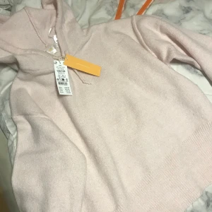 Ljusrosa hoodie från Gina Tricot - Säljer en mjuk och skön ljusrosa hoodie från Gina Tricot. Perfekt för en avslappnad stil med sin klassiska design och bekväma passform. Den har en huva och ribbade muddar vid ärmslut och nederkant.