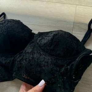 Intimissimi spetskorsett med snörning - Snygg svart korsett i spets med justerbara axelband och snörning bak. Dragkedja i sidan. Storlek M. Tycker den är aningen liten. 