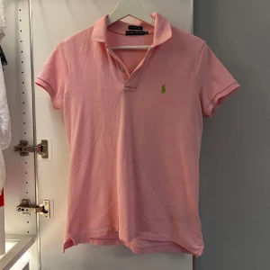Piké Ralph Lauren - Klassisk rosa pikétröja från Ralph Lauren med grön broderat logotyp på bröstet! Fint skick, där har varit ett litet hål som är sytt och fixat (se sista bilden) men inget man lägger märke till dock!💕 Den är knappt använd.