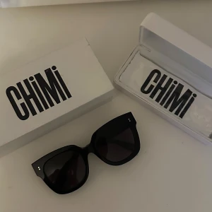 Svarta solglasögon från Chimi - Snygga svarta solglasögon från Chimi, modell #008 Berry. De har en bred båge och mörka linser, perfekt för en stilren look. Kommer med originalförpackning. Köpt för ca 1140kr
