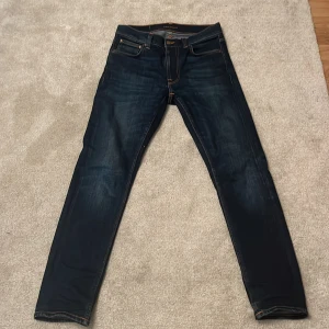 Mörkblå jeans från Nudie Jeans - Snygga mörkblå jeans från Nudie Jeans, modell Lean Dean. De är tillverkade i 99% bomull och 1% elastan för en bekväm passform. Jeansen sitter ganska slim.