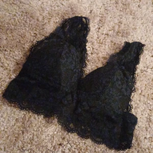 Svart spets bralette - Snygg svart bralette i spets med fina detaljer. Perfekt för att lägga till en touch av elegans under dina kläder. Den har en mjuk och bekväm passform. Saknar lapp men tror storlek s