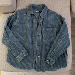 Blå manchester ”skjort/jacka” från Zara - Snygg blå Manchester jacka/skjorta från Zara. Jättefint skick, inga defekter. Strl XS men lite oversize. Bilderna 2 & 3 är tagna med blixt (den är inte så glansig i verkligheten)