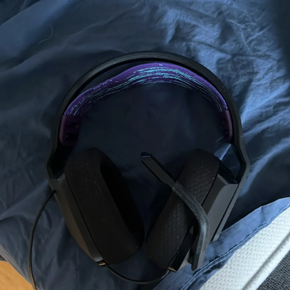 Snyggt svart gamingheadset med ett coolt blått mönster på insidan av huvudbandet. Perfekt för långa spelsessioner med bekväma öronkuddar och justerbar passform.. Asusteet.