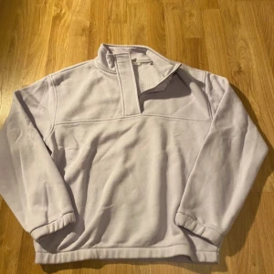 Ljuslila fleece från Yaya Women - Mysig ljuslila fleece från Yaya Women i storlek S. Perfekt för kyliga dagar med sin mjuka och varma känsla. Tröjan har en hög krage och långa ärmar, vilket gör den idealisk för höst och vinter.