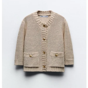Beige stickad kofta från Zara - Mysig beige stickad kofta från Zara med knappar framtill och två fickor. Perfekt för kyliga dagar med sin ribbade design vid ärmslut och nederkant. PRIS KAN DISKUTERAS!!