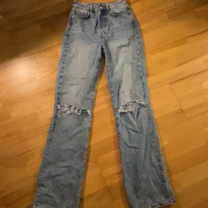 Blå jeans med slitningar - Snygga blå jeans med slitningar på knäna för en trendig look. Säljer då dem är för små och inte kommit till användning på ett bra tag! Pris går att diskuteras!🥰
