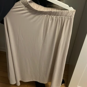 Beige kjol från JDY - Säljer en stilren beige långkjol från JDY i storlek S. Kjolen har en elastisk midja så den passar säkert XS och M🥰 Använd en gång💕