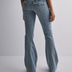 Blå bootcut jeans - Snygga blå bootcut jeans från true religon. Jeansen har en bekväm passform och är skit snygga . De har en knapp och dragkedja fram till. Fick dessa i julklapp så de är väldigt bra skick säljer endast för de är för stora för mig där av det köptes i fel storlek för mig. De är i storlek W27 