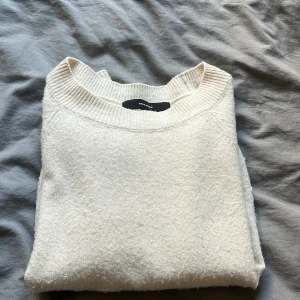 Vit stickad tröja från Vero Moda - Säljer en mysig vit stickad tröja från Vero Moda. Tröjan har långa ärmar och ribbade detaljer vid hals, ärmslut och nederkant. Perfekt för kyliga dagar. Hör av dig vid intresse! 🤍