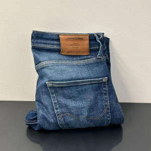 Blå jeans från Jack & Jones - Snygga blå jeans från Jack & Jones med en tapered fit. De har en klassisk femficksdesign och en knappgylf. Skick 8/10. Skriv vid frågor ✅