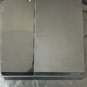 Svart PlayStation 4 från Sony - Säljer en svart PlayStation 4 från Sony. Konsolen har en stilren design med en blank och matt yta. Den har flera anslutningsportar inklusive HDMI och USB. Perfekt för gaming och underhållning!