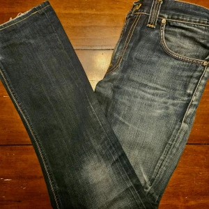 Nudie Jeans blå - Säljer dessa riktigt schyssta jeans från Nudie! Riktigt skön tvätt med snygg design på bakfickan. De är av utmärkt skick och i storlek W30/L32. Skriv vid frågor och funderingar!⭐️