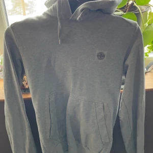 Grå stone island hoodie - Säljer nu min fina gråa stone island hoodie, den är i fint skick men en liten liten defekt vid snöret därav priset. Vid frågor eller funderingar skriv gärna, i sista bilden ser du hur den sitter på🤗 Strl, S/Xs. Sitter perfekt på mig som är 172.