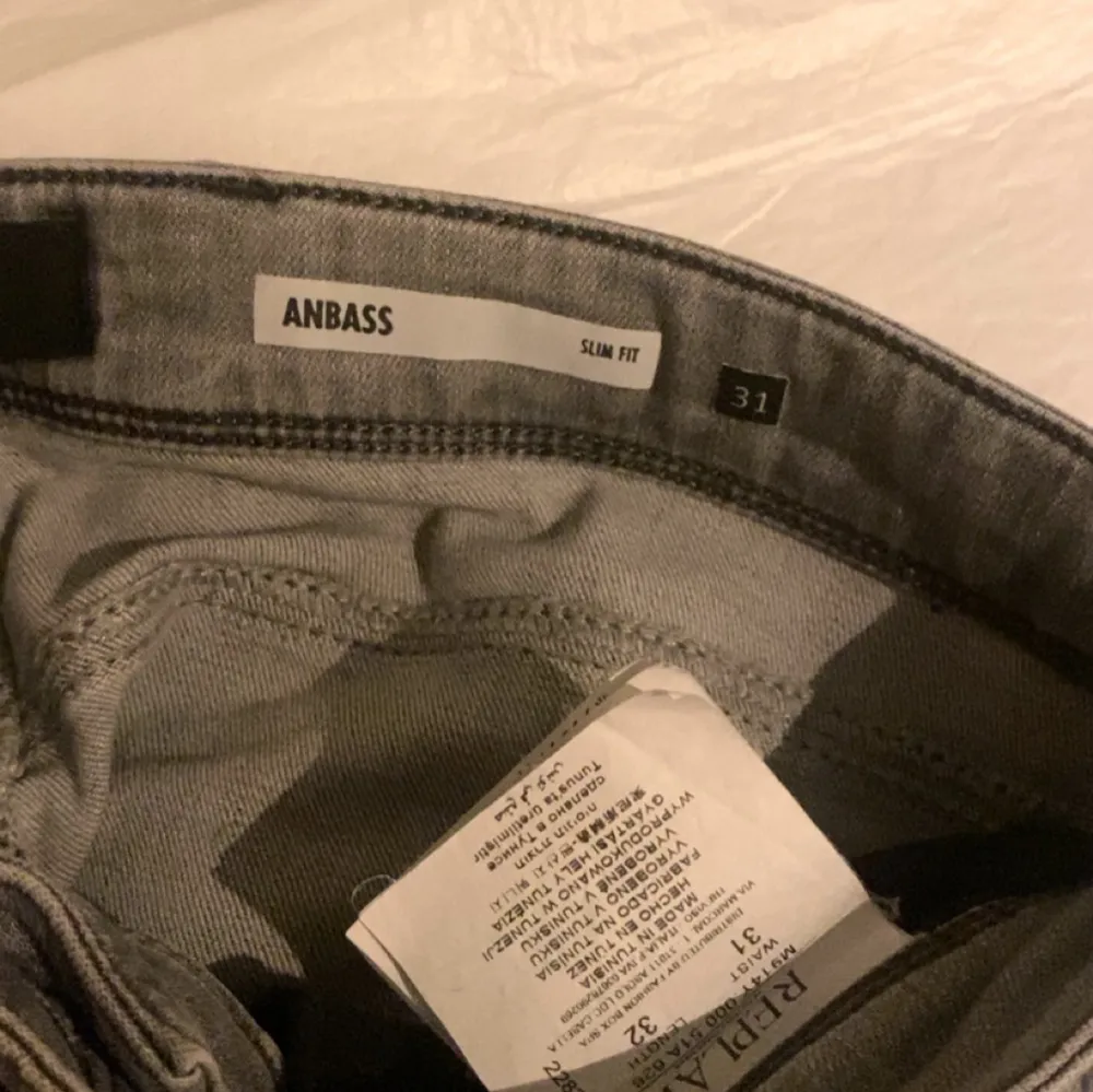 Snygga ljus grå jeans från Replay i modellen Anbass. De har en slim fit och klassisk femficksdesign med dragkedja och knapp. Perfekta för en stilren look. Säljer för de är knappt använda o använder de inte. Pris ej hugget i sten, kom med förslag. Farkut & Housut.