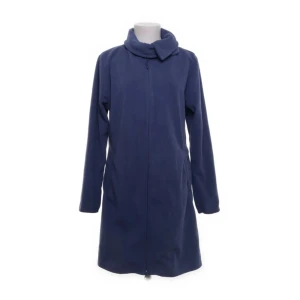 Ny blå lång fleecetröja strl M från Cane - Ny blå lång fleecetröja strl M från Cane i storlek M. Jackan är tillverkad av 100% polyester och har en dragkedja framtill. Perfekt för kyligare dagar med sin långa design och höga krage.