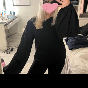 Svart tröja med vida ärmar - Säljer en stilren svart tröja med vida ärmar som ger en unik och trendig look. Perfekt för både vardag och finare tillfällen! Finns ingen lapp i men passar S/M