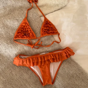 Orange bikini med volanger - Sååå SNYGG bikini! Har en liknande i gul som jag älskar så säljer därav denna🧡🧡 båda delarna är storlek S, säljer överdel & underdelen tillsammans