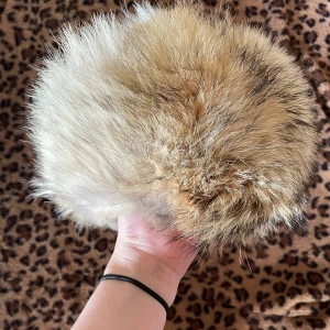 Fluffig pälsmössa - Säljer en superfluffig och varm mössa i beige och brun päls. Perfekt för kalla vinterdagar när du vill hålla dig varm och stilren. Mössan har en rund form och ger en lyxig känsla.