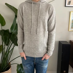 Merinoull Hoodie - En otroligt snygg ljusgrå Hoodie i 100% Merinoull! Storlek M, modellen är runt 180 men passar även lite större än det🌟. Använd max 3 gånger, inga defekter! Hör av dig vid intresse😊