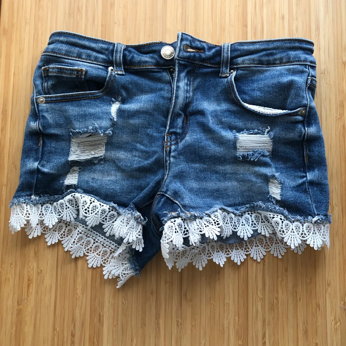 Blå jeansshorts med spetsdetaljer från Hailys