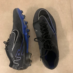 Nike air zoom mercurial vapor 15 elite AG - Storlek 42, normal i storleken. Skorna har använts under 3 månader och är därmed i väldigt bra skick. En liten spricka på båda skorna därför är priset nedsatt då urspringspriset på skorna ungefär är 3149 kr. Priset kan diskuteras.