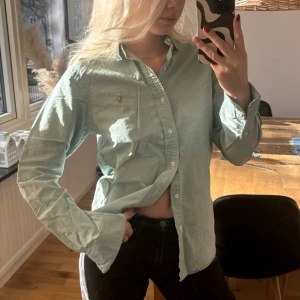 Skjorta - Ljusblå skjorta från Ralph Lauren. Har en liten tråd som dragit längst upp på vänstra axeln (se bild 4), men märks knappt. Annars toppen skick! 