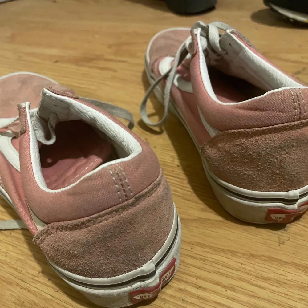 Säljer ett par rosa Vans sneakers med vit sula och snörning. Skorna har en klassisk design med den ikoniska sidostripen i vitt. Perfekta för en avslappnad stil. Det syns att det är använda då de är smutsiga men annars är det helt användbara utan några skador!. Kengät.