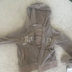 Tröja från Juicy Couture - Pris kan diskuteras! Säljer beige kofta från Juicy Couture med glittrande detaljer på framsidan och en dragkedja.