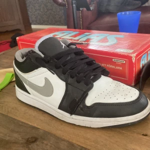 Svarta och vita Nike Air Jordans - Säljer ett par snygga Nike Air Jordans i svart,vitt och grå, Skorna är i ganska bra skick.  De är tillverkade i skinn och har en bekväm passform. Perfekta för både vardag och fest! ( den är lite sliten uppe på skorn och ett litet slitet märke under också. Ordinarie pris: 1 500 , priset kan diskuteras.