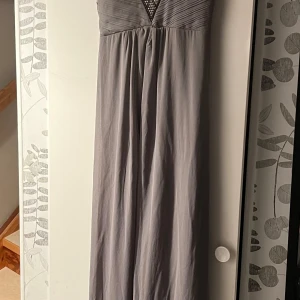 Balklänning/festklänning strl M - En fantastiskt vacker bal/festklänning som aldrig blev använd. Den har bara hängt i garderoben. Från Sisters Point i storlek medium. Fin strass kring bysten och ett otroligt fall i klänningen. Smock i livet baktill så den är stretchig. 