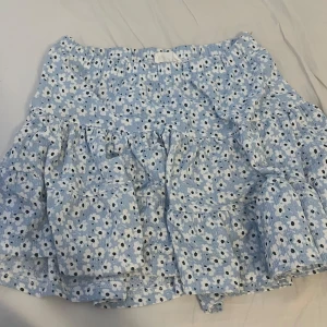 Kjol - Ljusblå kjol med blommor från förra årets lager 157! Storlek 160 men passar fint på mig som är 156 ungefär.